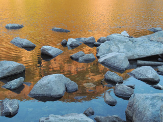 Fototapeta na wymiar Golden Reflection On A Mountain Lake