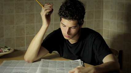 a man reading in a newspaper looking for a job - seeking work