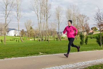 Young woman running on a cold winter day © SPJE_ART