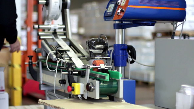 worker puts tubes of cream in the machine for label