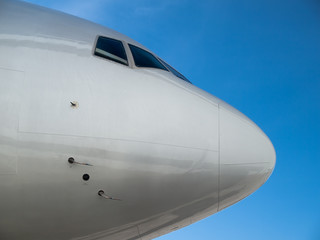 Fototapeta na wymiar Airplane nose close up isolated on blue sky