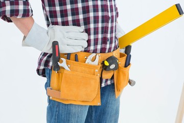 Repairman wearing tool belt while standing with hands on hips