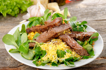 Roast beef with salad of arugula and lettuce with egg