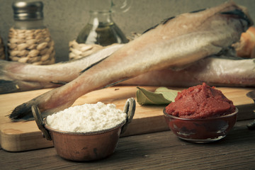 Fresh fish, vegetables, flour, tomatoe paste and spices on a woo