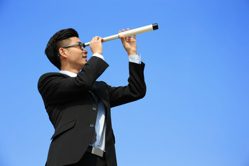 Businessman with telescope looking forward