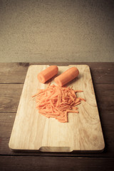 Sliced carrots on a wooden cutting board. Toned