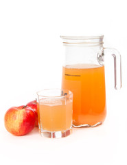 Jug of freshly squeezed apple juice, glass and two apples