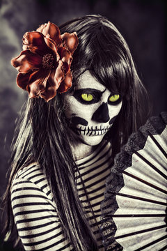 Young woman in day of the dead mask skull face art.