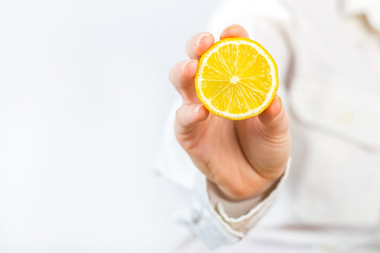 women Hand Holding a lemon isolated on white