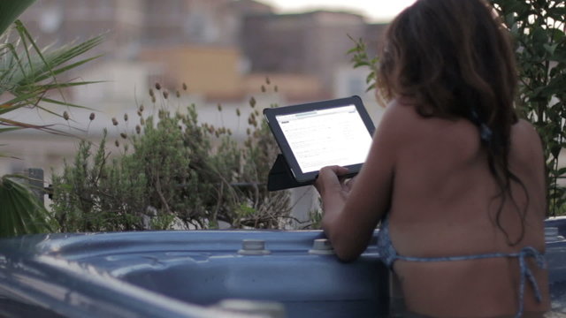 luxury spa - woman surfing in internet on tablet in whirlpool bath - jacuzzi
