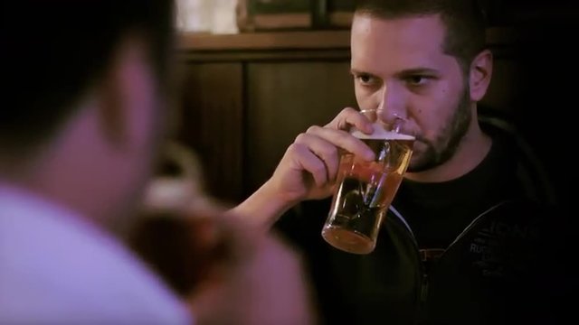 Two men toasting beer in a pub