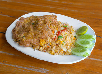 Pork fried rice with omelet on wood table
