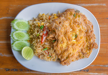 fried rice with omelet on wood table