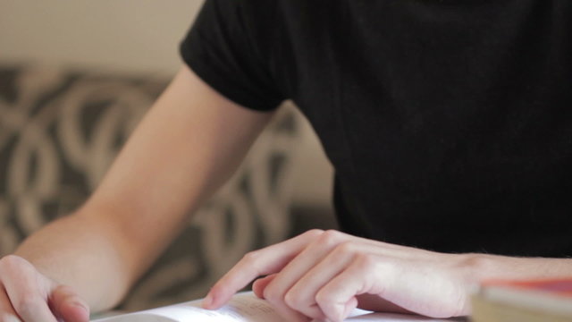 Young man reading a book on the desk