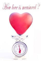 Love measure concept. Red heart balloon is weighted on scale