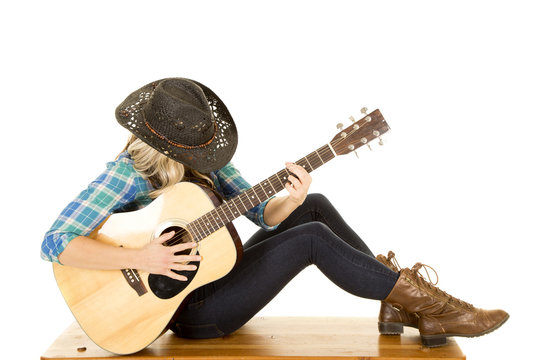 cowgirl with guitar in blue shirt sit knees