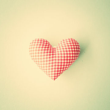 Vintage cotton stuffed heart over blue background