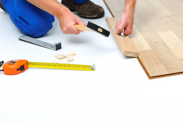 Fototapeta na wymiar Man laying laminate flooring