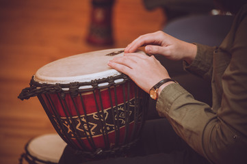person playing on Jambe Drum