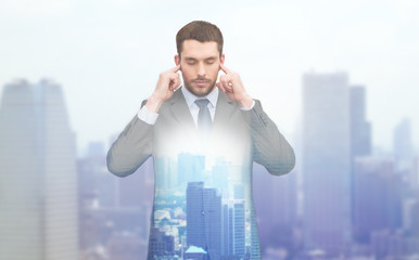annoyed businessman covering ears with his hands