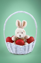 Easter bunny with red eggs in the basket