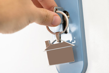 Obraz premium Finger Inserting Key In Keyhole