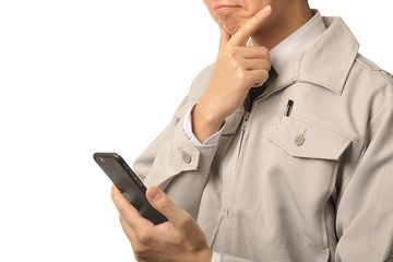 スマートフォンを活用している作業服の男性