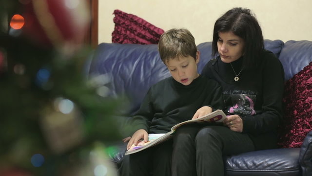 Mom and little son reading the stories about the legend of the Christmas