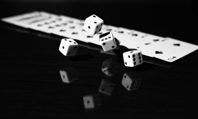 A gambler rolling the dice to win. on a reflective surface with 