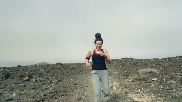 Portrait of happy woman jogging on desert