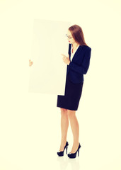 Naklejka premium Beautiful business woman holding empty board.
