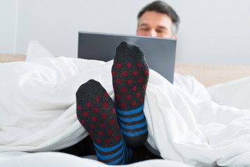 Man With Socks In His Leg Using A Laptop