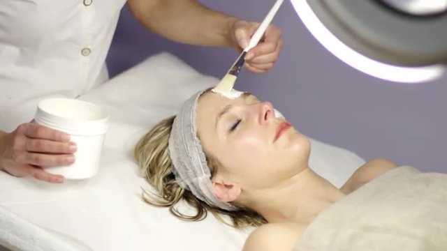 spa, beautiful woman making a facial mask