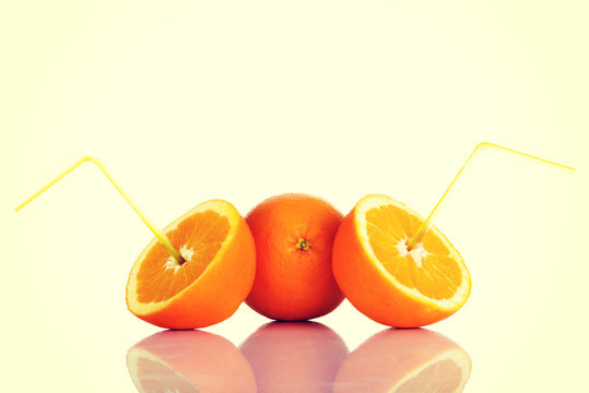 Fresh oragnes with straws.