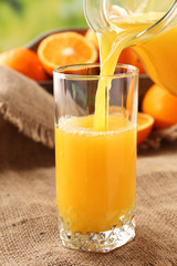 Pouring orange juice from glass carafe,