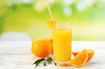 Glass of orange juice with straw and slices