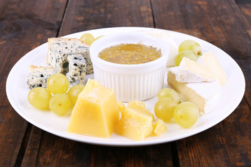 Different sort of cheese with grape and saucer