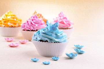 Delicious cupcakes on beige background