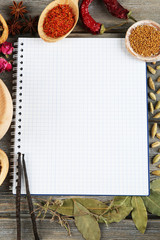 Spices with recipe book on rustic wooden table background