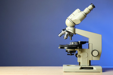Microscope on table, on color background