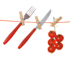 Fork, knife and ripe red tomatoes hanging from clothesline