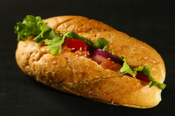 Sandwich with salmon on dark wooden background