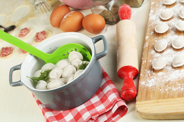 Raw and cooked dumplings close-up in kitchen