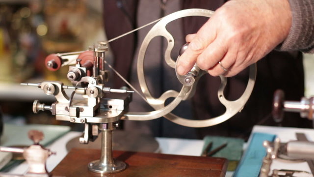 clockmaker working with a antique lathe