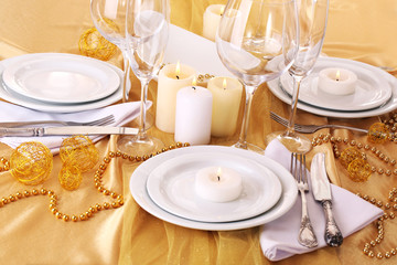 Beautiful holiday table setting in white and gold color