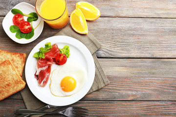 Bacon and eggs on rustic wooden planks background