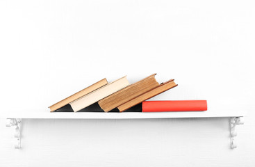 Old books on bookshelf on white wall background