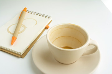 an empty coffee cup and notebook