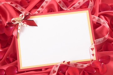 Valentine card with ribbon and rose petals