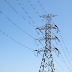 electric high voltage power post with blue sky background